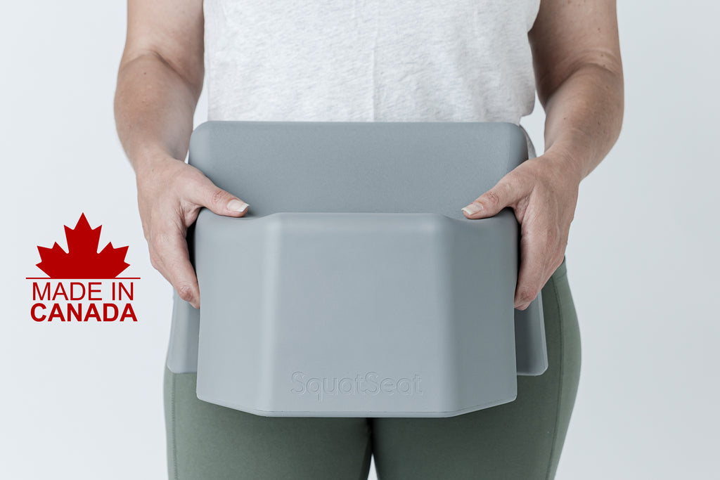 A person holding a gray SquatSeal fitness pad against their torso, wearing a white tank top and olive green leggings. A red 'Made in Canada' graphic overlay is visible on the left side.